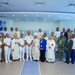 Director General Grupo de autoridades militares, religiosas,Subdirectores y Directores posando juntos en el salón Juan Pablo Duartes, bocinas en los laterales y banderas de fondo.