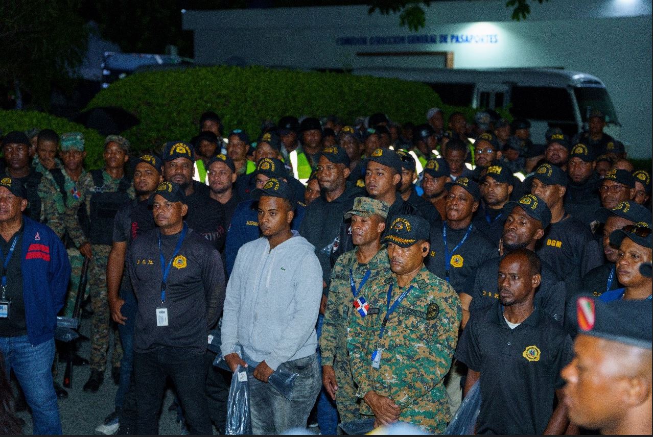 Grupo de agentes migratorios en atención, de fondo autobús, operativo nocturno.