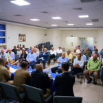 Director general y demas autoridades dgm sentados en mesa, hablando con el sector agropecuario en el salón Juan Pablo Duarte