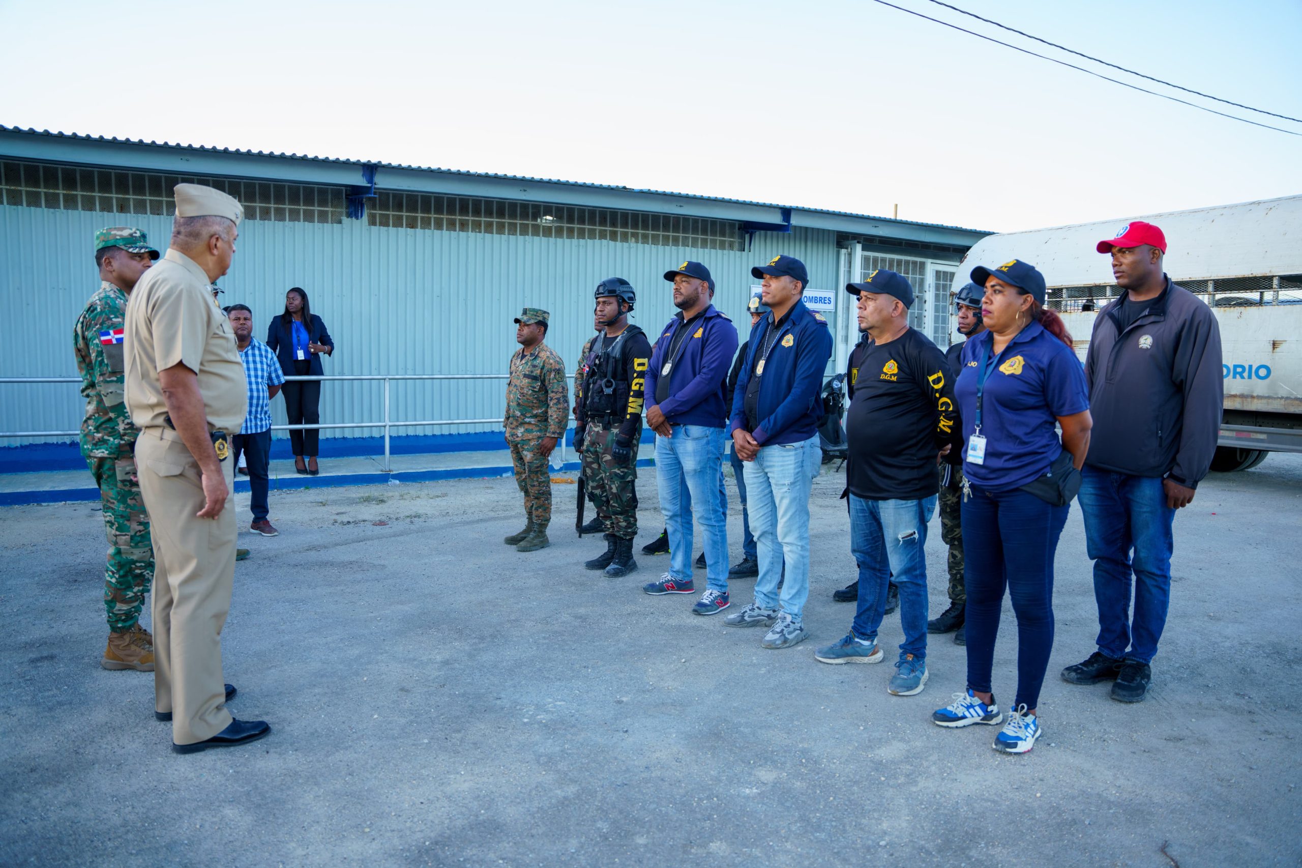 Vicealmirante Lee ballester con agentes de interdición afuera de las oficinas con un camión detras