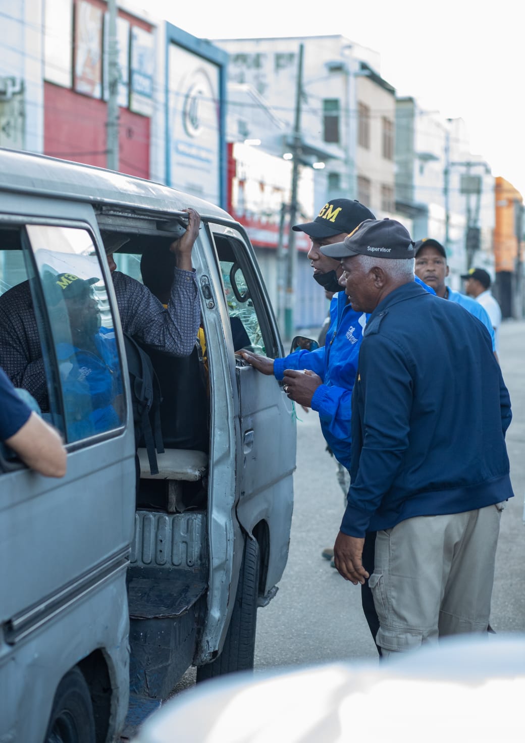 Immigration interdiction agents inspecting a public vehicle on the street