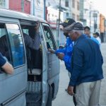 Agentes de interdición migratoria, inspeccionando una vehículo publico en la calle