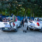 Operativo migratorio con dos camionetas y agentes transportando nacionales haitianos.