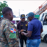 Immigration agent stopping a foreigner on the street and checking his documents with a soldier next to him