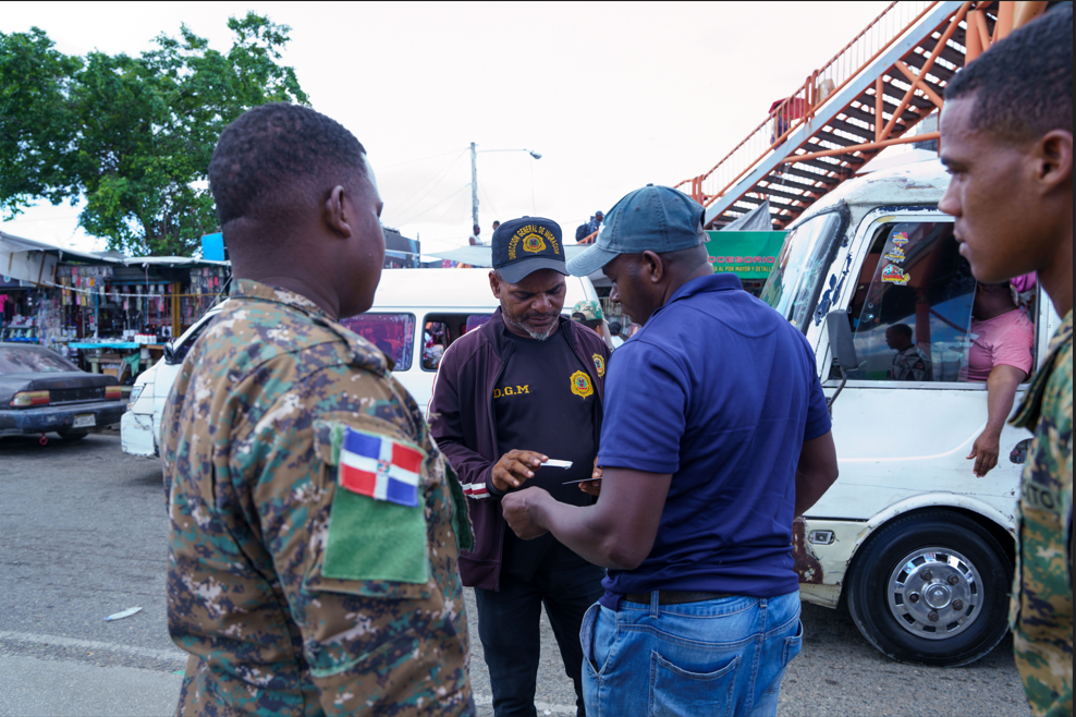 Immigration agent stopping a foreigner on the street and checking his documents with a soldier next to him