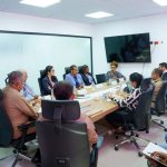 Photo of meeting in the hall, with DGM authorities sitting in black chairs next to each other.