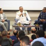 Director General, Director de extranjería, Directora jurídica sentados en uno al lado de otros en conversatorio sobre la regulación migratoria en RD en la universidad PUCMM