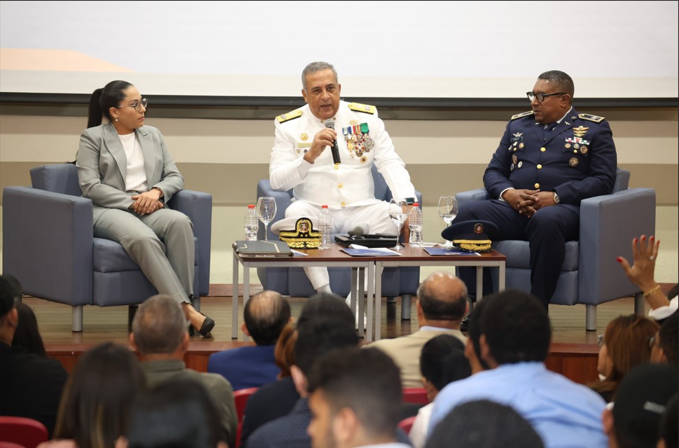 Director General, Director de extranjería, Directora jurídica sentados en uno al lado de otros en conversatorio sobre la regulación migratoria en RD en la universidad PUCMM