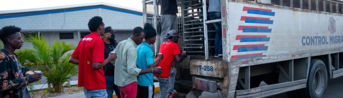 Foreigners with irregular status boarding an immigration control truck at the Haina resort.