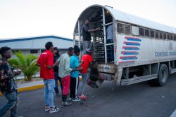 Extranjeros en estatus irregular, subiendo a camión de control migratorio en el centro vacacional de Haina.