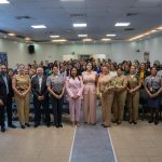 foto grupal con autoridades de la DGM en salón Juan Pablo duarte de la sede central todos parados de frente a cámara en celebración al día internacional de la mujer.