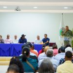 Foto de director en podium para hablandole a las personas que forman parte y trabajan en el mercado binacional de Dajabón, acompañado por el alcalde de dicha provincia y su gobernador.