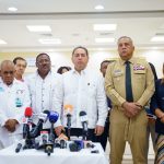 SNS and DGM directors standing in front of microphones at a press conference.