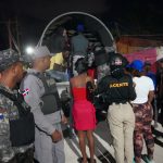 Immigration and police officers operating behind a truck, loading undocumented foreigners