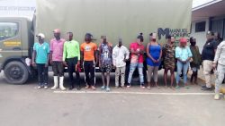Illegal foreigners detained, all standing in front of an immigration