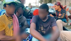 extranjeros ilegales detenidos montados en camioneta sentados.