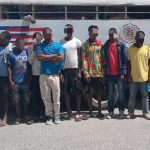 Illegal foreigners detained, all standing in front of an immigration