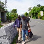 Immigration agent walking with undocumented foreigner detained in interdiction operation.
