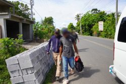 Agente migratorio caminando con extranjero indocumentado detenido en operación de interdicción.