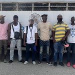 Illegal foreigners detained, all standing in front of an immigration