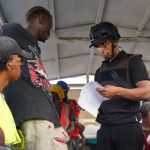 agente migratorio chequeando en camión a extranjeros detenidos en condición irregular.
