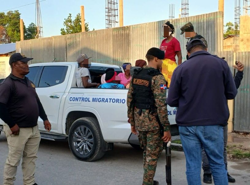 Immigration interdiction agents standing on the street, illegally loading foreigners into a van.