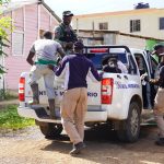 Agents loading undocumented foreigners into immigration control van after operation
