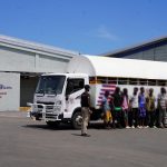 Immigration agent standing in front of a truck with undocumented foreigners at the Haina interdiction center.