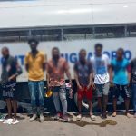 Extranjeros irregulares detenidos, todos parados frente a camión control migratorio.